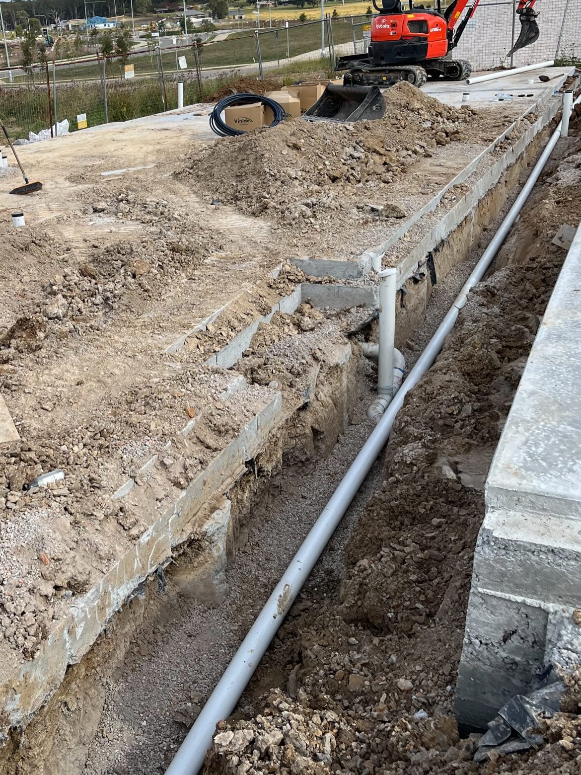 Drainage line installed through a prepared construction trench
